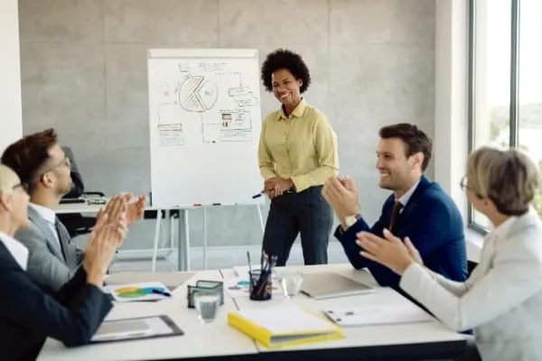 Equipo de trabajando aplaudiendo luego de una presentación