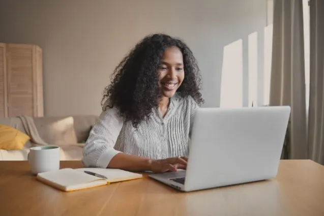 mujer mirando a computadora feliz
