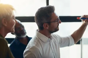 Líder conduce una reunión de seguimiento de desempeño en la sala de directorio.