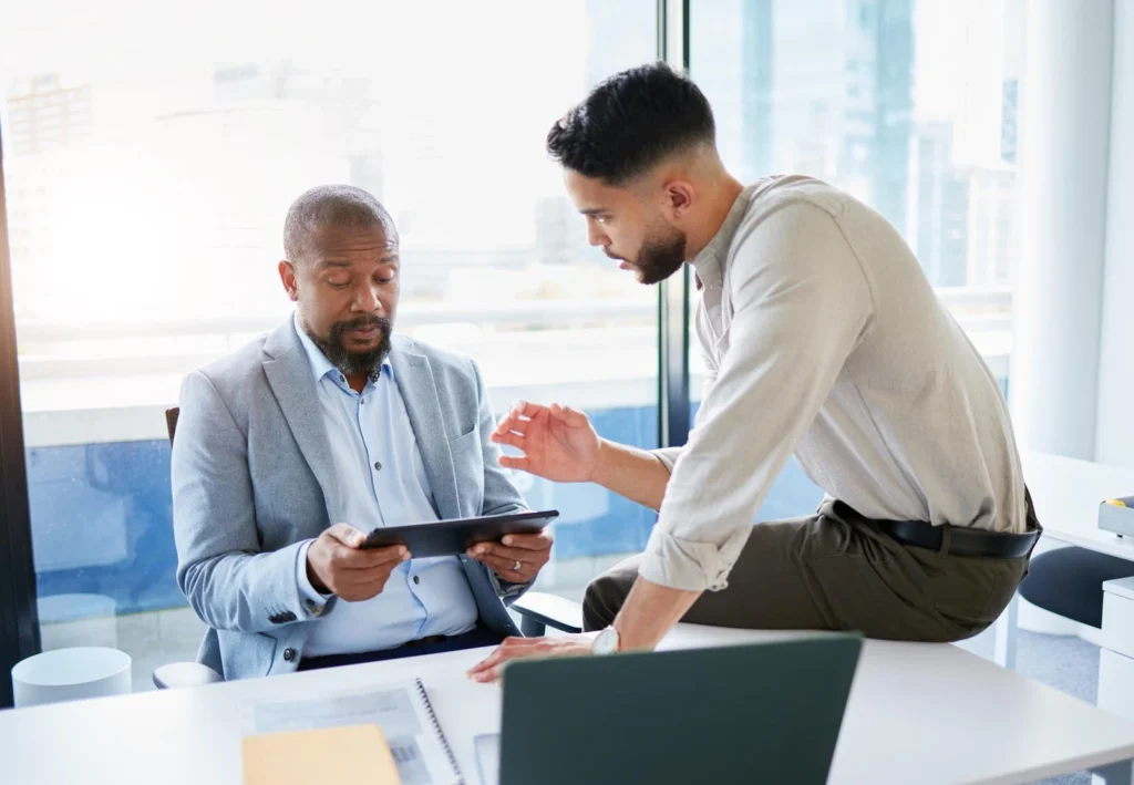 Equipo de trabajo revisa una propuesta en una tablet durante una reunión en la oficina.