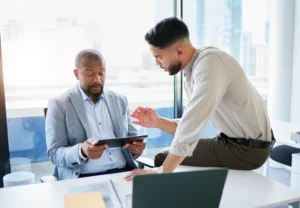 Equipo de trabajo revisa una propuesta en una tablet durante una reunión en la oficina.