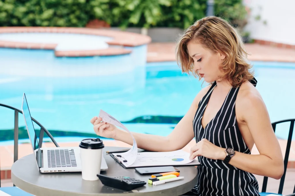 Profesional revisa documentación laboral sentada a una mesa al aire libre.