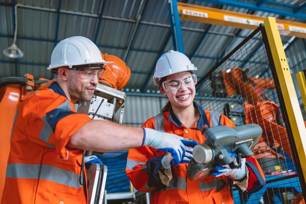 Equipo de técnicos opera un brazo robótico en una planta metalúrgica.